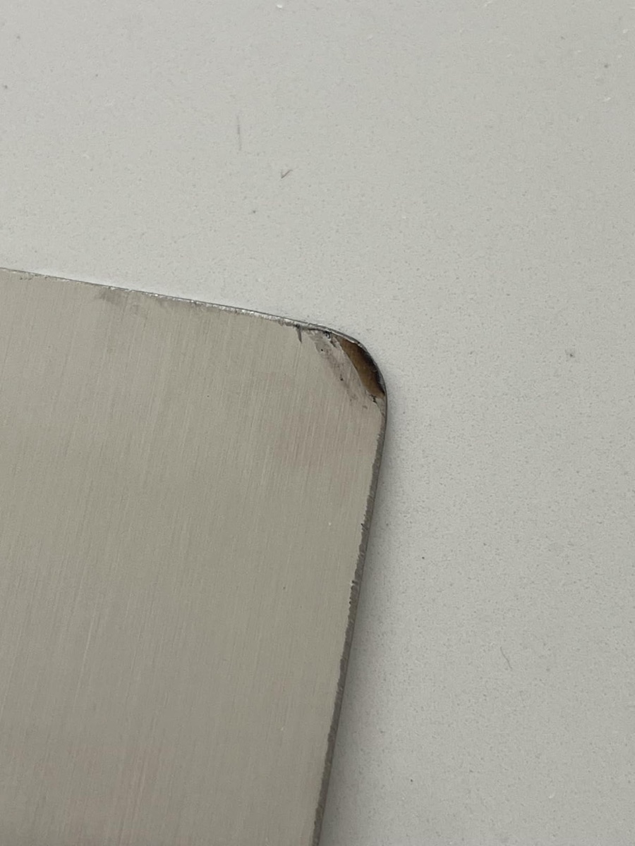 Amazon “stainless” board with the thin plating chipping off the corner, exposing base metal