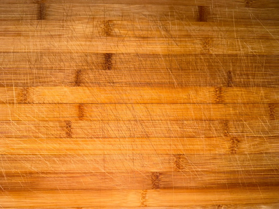 Bamboo cutting board covered in deep knife scoring